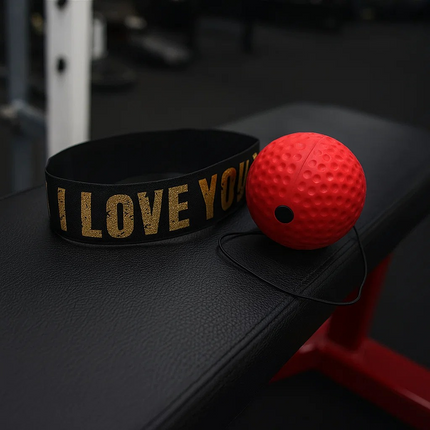 Black band with 'I LOVE YOU' text and a red ball on a dark surface. boxing game
