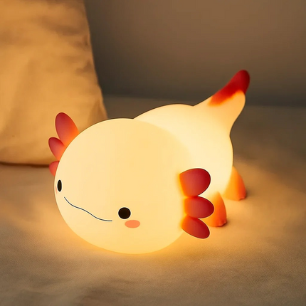 Axolotl-shaped night light on a soft surface with a blurred background