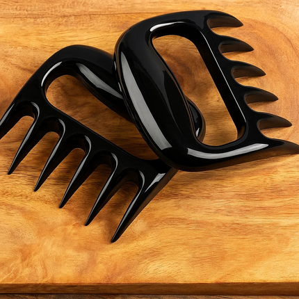 Black meat shredder claws on a wooden surface