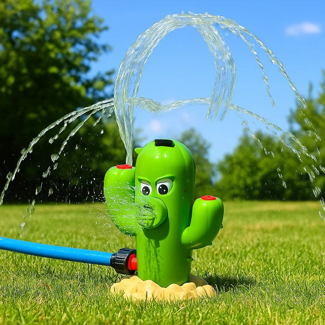 Cactus-shaped sprinkler spraying water on a grassy area with trees and blue sky in the background