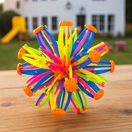 Colorful classic fidget toy expandable  spherical toy with multiple arms on a wooden surface, playground in the background